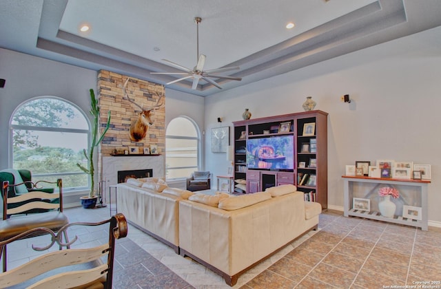 2110 Winding Vw, San Antonio, TX 78260 - living area with baseboards, a fireplace, ceiling fan, and a raised ceiling