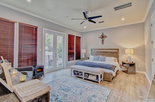 2110 Winding Vw, San Antonio, TX 78260 - bedroom with french doors, visible vents, wood finished floors, access to exterior, and a wood stove
