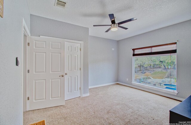 2110 Winding Vw, San Antonio, TX 78260 - unfurnished bedroom featuring visible vents, carpet floors, a textured wall, and a textured ceiling