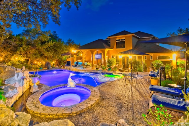 2110 Winding Vw, San Antonio, TX 78260 - pool at night featuring a pool with connected hot tub and a patio area
