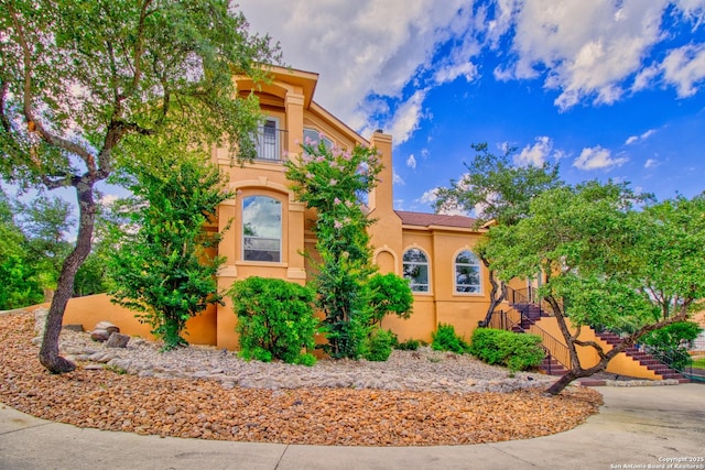 2110 Winding Vw, San Antonio, TX 78260 - view of front of home featuring a balcony, a chimney, stucco siding, and stairway