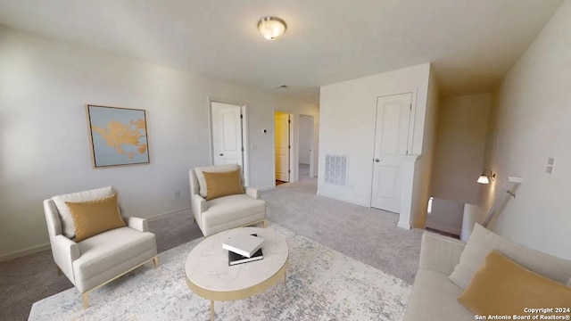living area featuring baseboards, visible vents, and carpet flooring