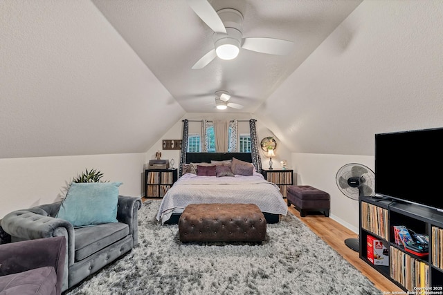 bedroom featuring a textured ceiling, baseboards, ceiling fan, lofted ceiling, and light wood-type flooring
