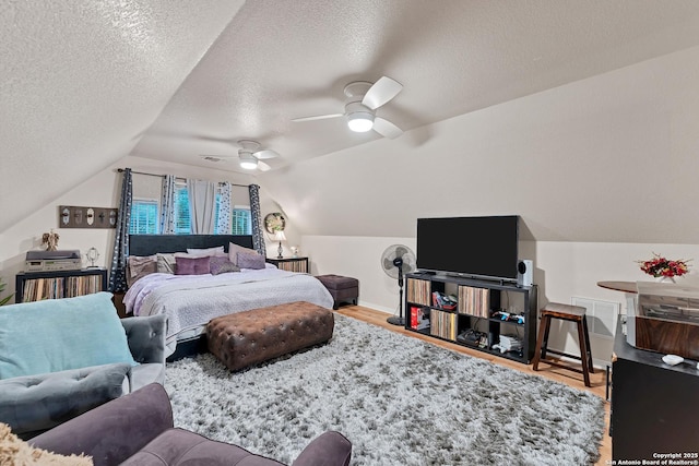 bedroom featuring vaulted ceiling, baseboards, a textured ceiling, ceiling fan, and wood finished floors