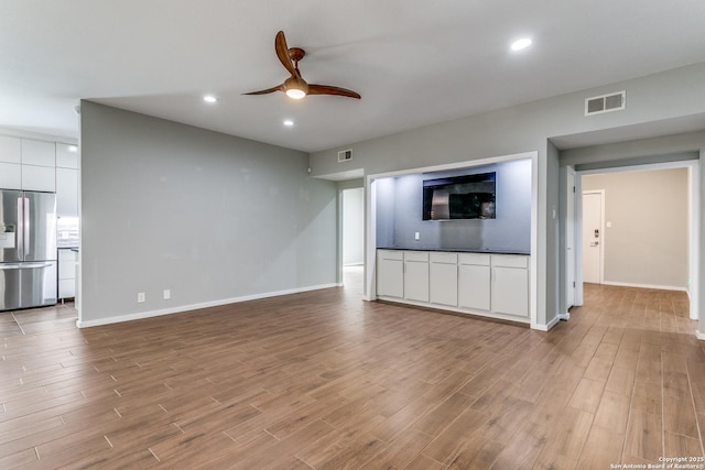 unfurnished living room with visible vents, recessed lighting, a ceiling fan, and wood finished floors