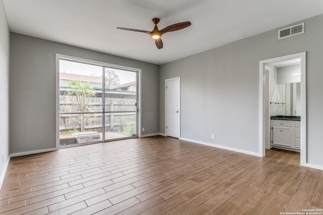 unfurnished room with a ceiling fan, wood finished floors, baseboards, and visible vents
