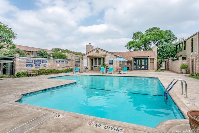 community pool featuring fence and a patio area