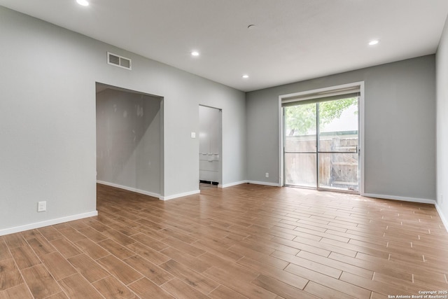 spare room with wood finished floors, recessed lighting, and visible vents