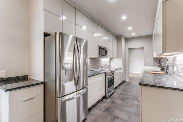 kitchen with dark stone countertops, stainless steel appliances, recessed lighting, and tasteful backsplash