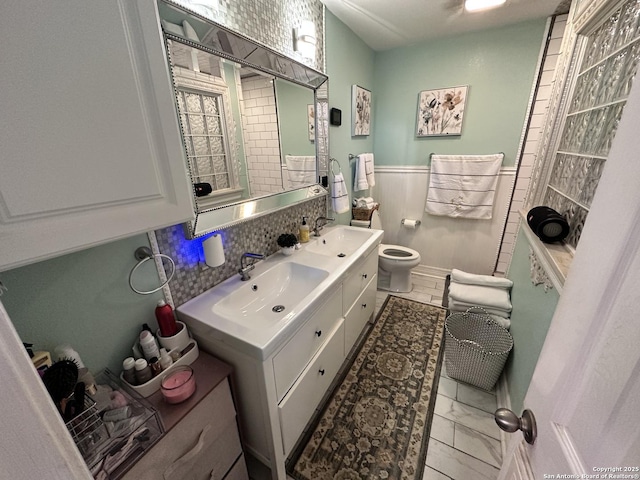 3401 Sugarhill, San Antonio, TX 78230 - full bathroom featuring double vanity, wainscoting, toilet, and a sink