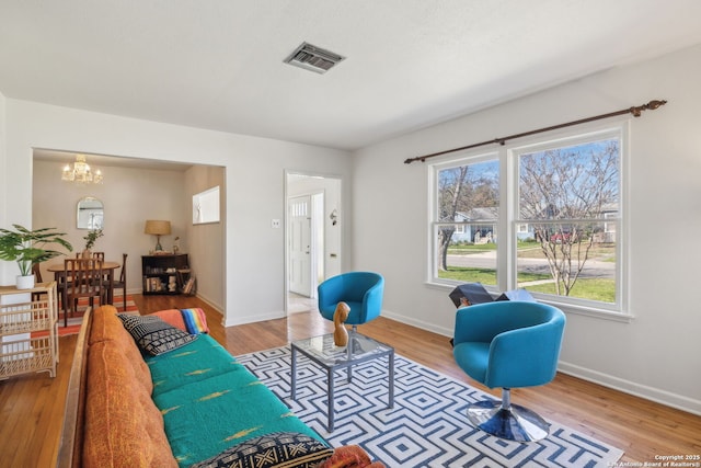 2334 W Huisache, San Antonio, TX 78201 - living room featuring wood finished floors, baseboards, a chandelier, and visible vents
