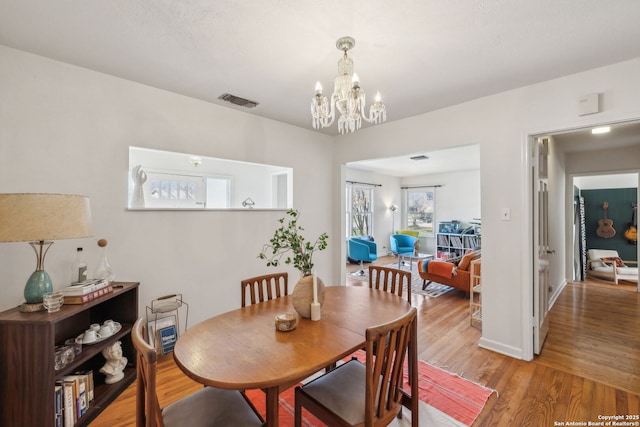 2334 W Huisache, San Antonio, TX 78201 - dining space featuring baseboards, light wood-style floors, a chandelier, and visible vents