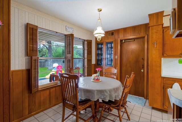 3422 William Penn Dr, San Antonio, TX 78230 - dining room featuring light tile patterned flooring, visible vents, wood walls, wallpapered walls, and wainscoting