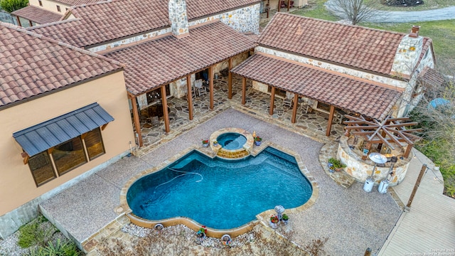 pool featuring an in ground hot tub and a patio area
