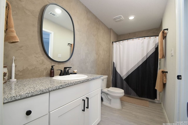 full bathroom with toilet, vanity, wood finished floors, and visible vents