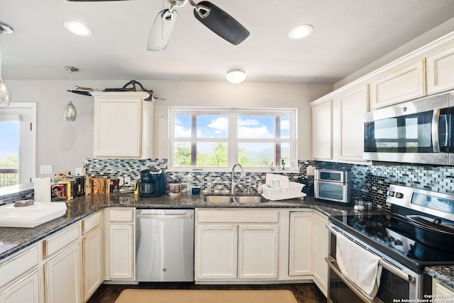 kitchen featuring plenty of natural light, a sink, backsplash, and appliances with stainless steel finishes
