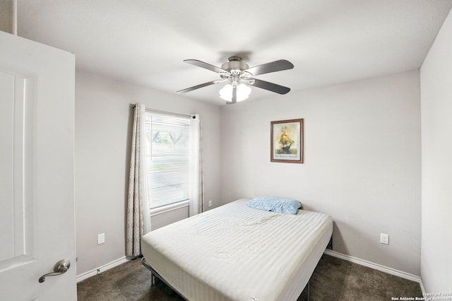 bedroom with baseboards, dark carpet, and a ceiling fan