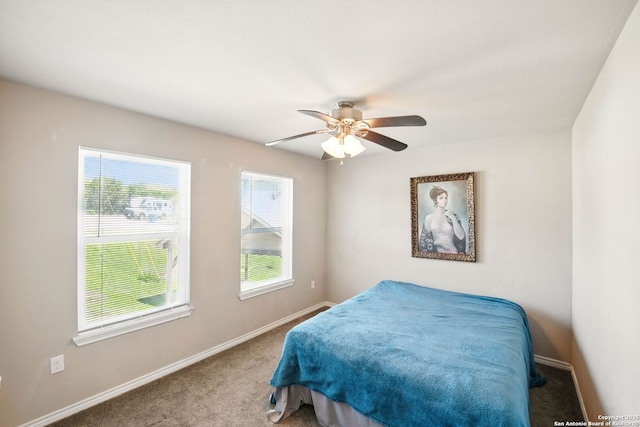 carpeted bedroom featuring baseboards and a ceiling fan