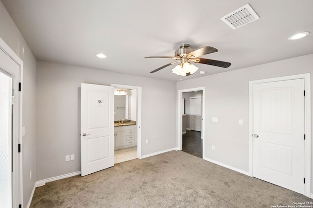 unfurnished bedroom featuring recessed lighting, baseboards, ensuite bath, visible vents, and light carpet