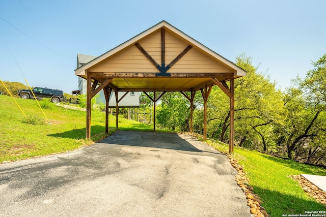 view of vehicle parking featuring driveway and a carport