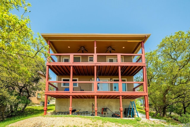 back of property featuring a balcony and a ceiling fan