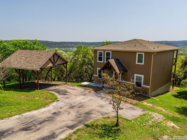 view of front of home with driveway, stucco siding, and a front yard