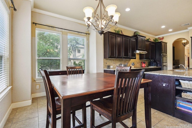 dining room featuring visible vents, plenty of natural light, a notable chandelier, and arched walkways