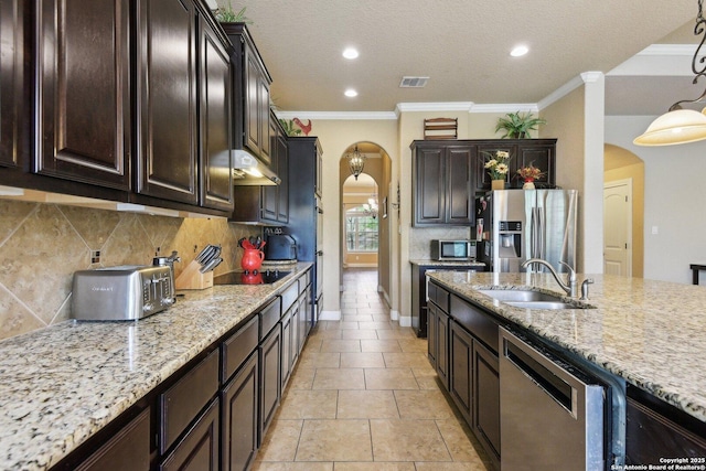 kitchen featuring visible vents, arched walkways, stainless steel appliances, and a sink