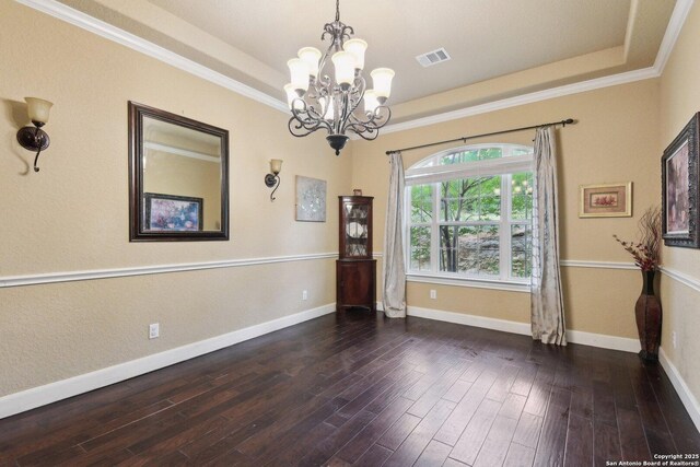 unfurnished room with baseboards, visible vents, a notable chandelier, and a tray ceiling