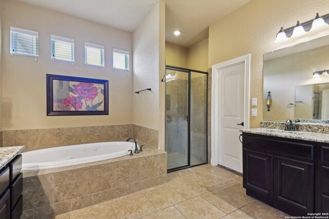 full bathroom with tile patterned flooring, a textured wall, a bath, vanity, and a stall shower