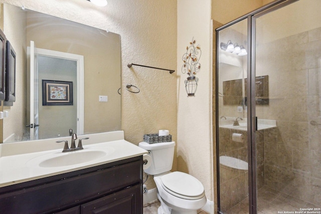 full bath with toilet, a stall shower, a textured wall, and vanity