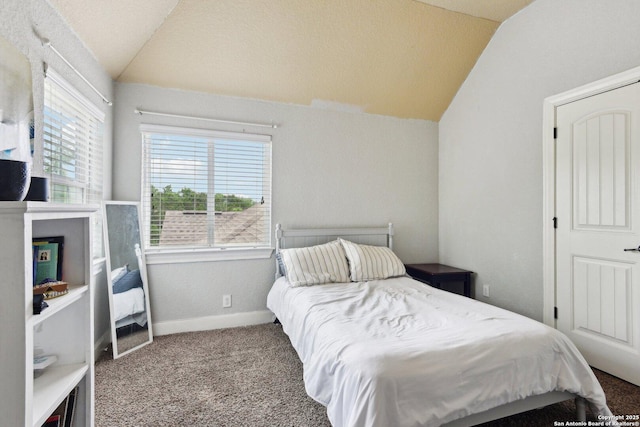 bedroom featuring baseboards, carpet flooring, and vaulted ceiling