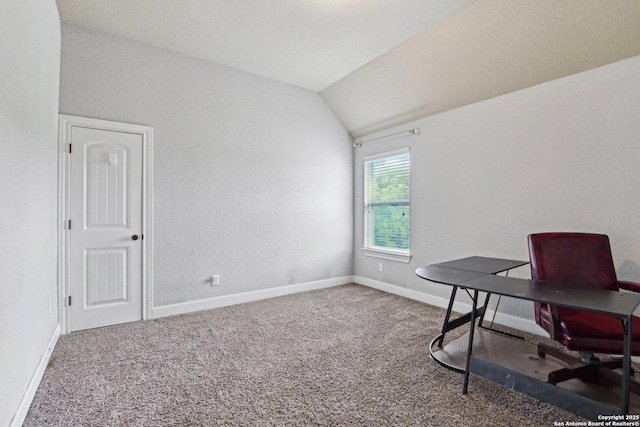 home office with lofted ceiling, a textured wall, baseboards, and carpet floors