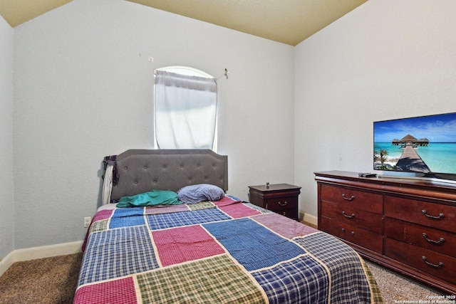 carpeted bedroom featuring lofted ceiling and baseboards