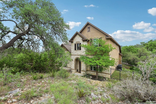exterior space with fence and stone siding