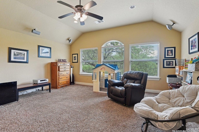 living area with visible vents, ceiling fan, vaulted ceiling, and carpet floors