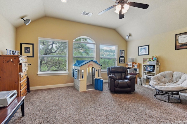 living area featuring visible vents, a healthy amount of sunlight, a ceiling fan, and vaulted ceiling
