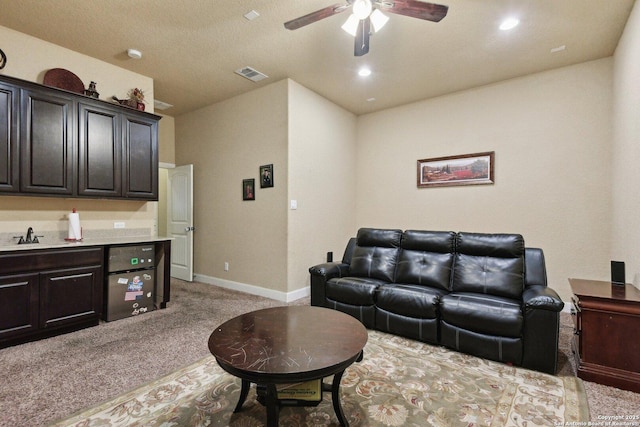living area featuring ceiling fan, baseboards, light carpet, and visible vents
