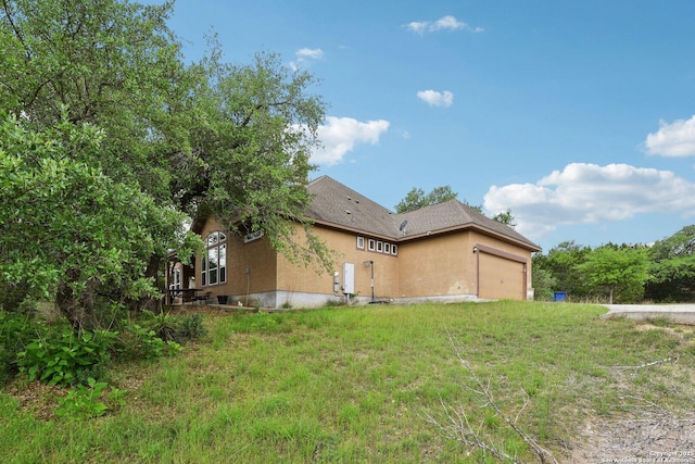 view of side of property featuring stucco siding and a garage