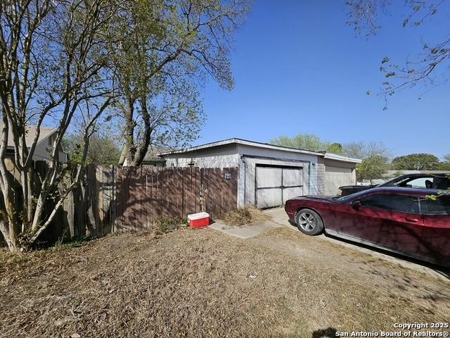 view of property exterior with fence and an outdoor structure