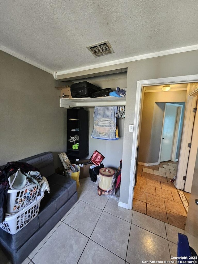 interior space with a textured ceiling, baseboards, and visible vents