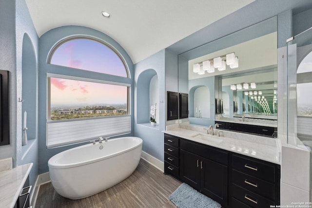 6743 Bella Colina, San Antonio, TX 78256 - full bath featuring a freestanding tub, vanity, wood finished floors, lofted ceiling, and baseboards