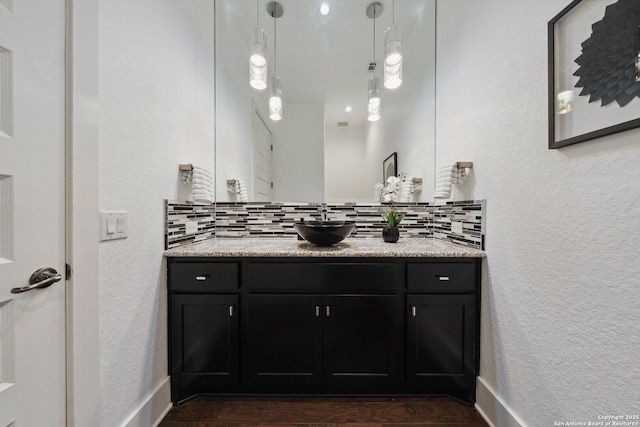 6743 Bella Colina, San Antonio, TX 78256 - bathroom with a textured wall, wood finished floors, decorative backsplash, and vanity