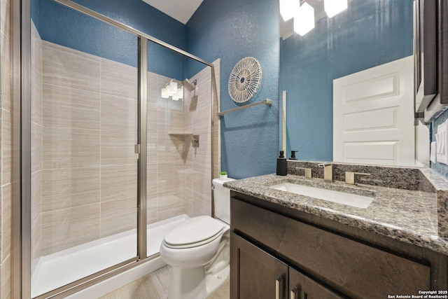 6743 Bella Colina, San Antonio, TX 78256 - bathroom with a textured wall, a stall shower, toilet, and vanity