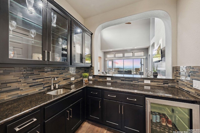 6743 Bella Colina, San Antonio, TX 78256 - kitchen with wine cooler, dark stone countertops, a sink, dark cabinetry, and backsplash