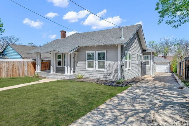 ranch-style house with a front lawn, a chimney, an outbuilding, and fence