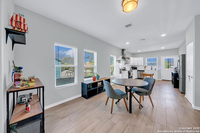 dining room featuring light wood-type flooring, recessed lighting, baseboards, and visible vents