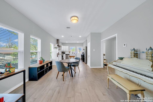 dining area featuring baseboards, light wood-style flooring, and recessed lighting