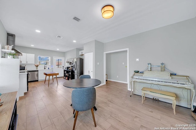 interior space featuring baseboards, visible vents, recessed lighting, and light wood-type flooring