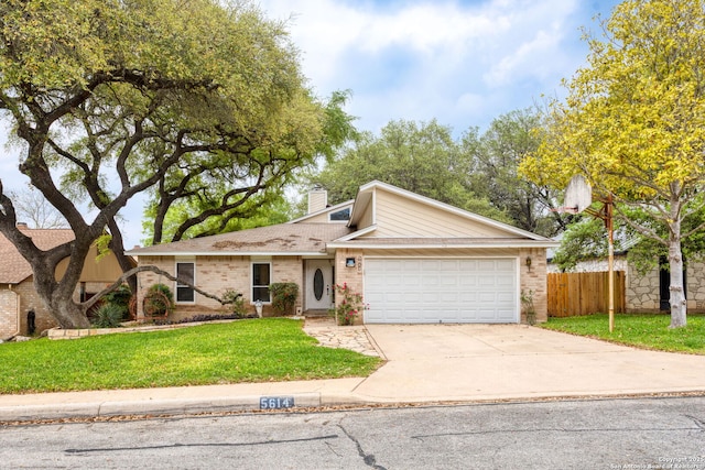 view of front of home with driveway, an attached garage, fence, brick siding, and a front lawn